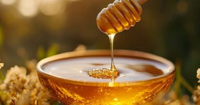 Goldglänzender Honig läuft von einem Honiglöffel