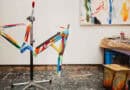 Bunt bemalter corratec LIFE S Fahrradrahmen auf einem Montageständer im Atelier.