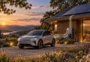 Elektroauto vor einem modernen Wohnhaus bei Sonnenuntergang. Auf dem Dach befindet sich eine Photovoltaikanlage, daneben ist eine Ladeeinrichtung zu sehen. Eine visualisierte Energieverbindung zwischen Fahrzeug und Haus verdeutlicht das Prinzip des bidirektionalen Ladens. Das im Ausgangsdokument auf Seite 2 verwendete Motiv verbindet damit die drei Kernthemen Elektromobilität, Photovoltaik und häusliche Energieversorgung.