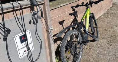 corratec E-Power X-Vert Pro Team an einer öffentlichen E-Bike-Ladestation.