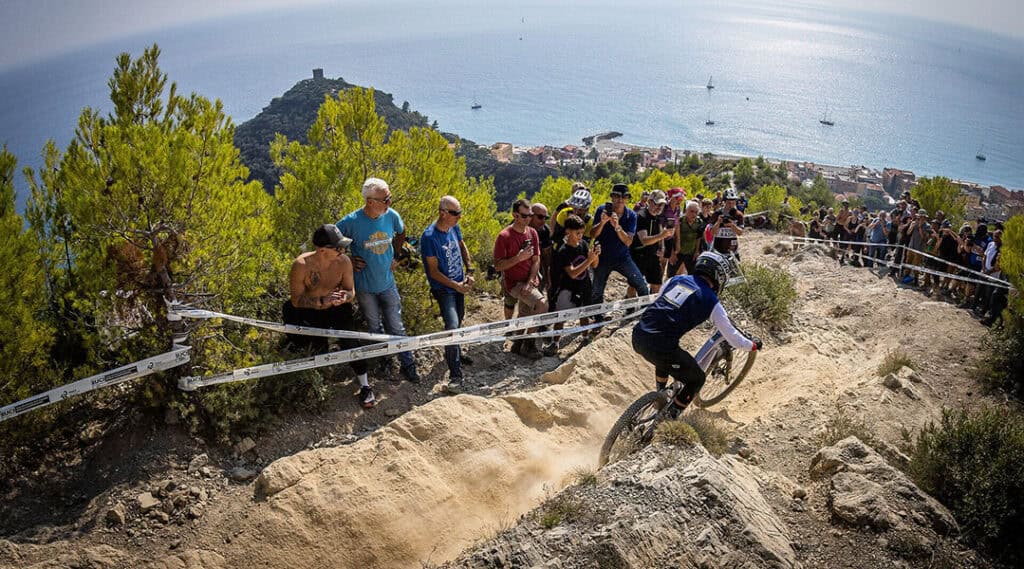 Adrien Dailly fährt bei der E-Enduro-WM 2026 einen felsigen Trail oberhalb der Mittelmeerküste von Finale Ligure.