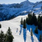 Zwei Menschen unterwegs in verschneiter Berglandschaft im Tannheimer Tal.