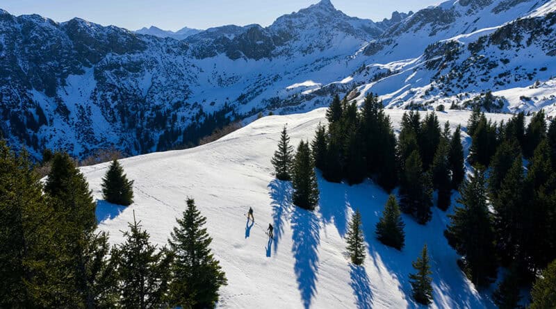 Zwei Menschen unterwegs in verschneiter Berglandschaft im Tannheimer Tal.