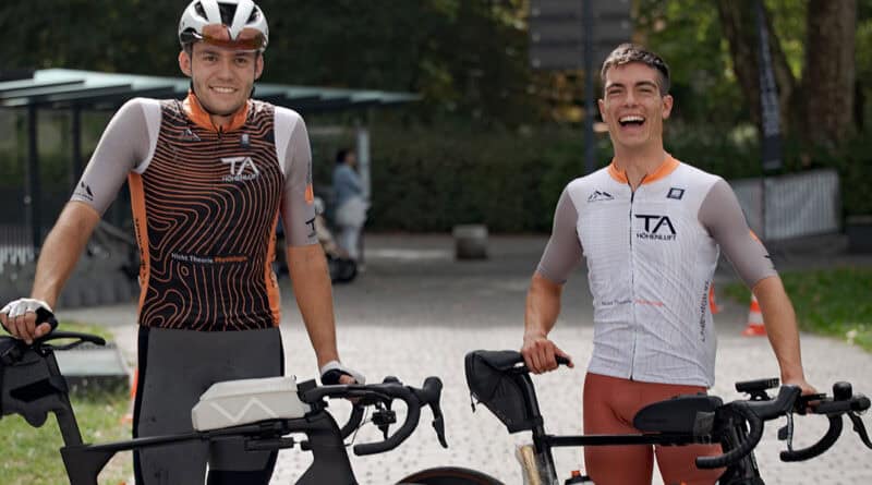 Zwei Rennradfahrer stehen nach dem Race Across Austria lächelnd mit ihren Fahrrädern am Zielort Feldkirch.