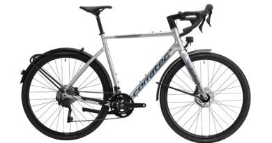 Silbernes corratec ALLROAD A EQ Gravelbike mit Schutzblechen, Gepäckträger, Lichtanlage und Rennlenker in Seitenansicht.