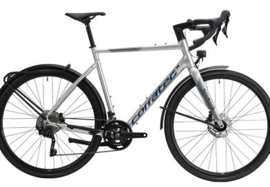 Silbernes corratec ALLROAD A EQ Gravelbike mit Schutzblechen, Gepäckträger, Lichtanlage und Rennlenker in Seitenansicht.