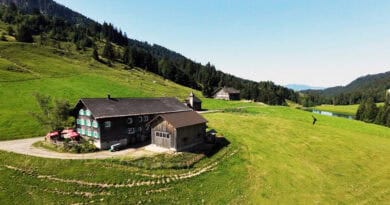 Alpe Höfle im grünen Lecknertal mit Alpengasthof, Bergwiesen, Wald und See.