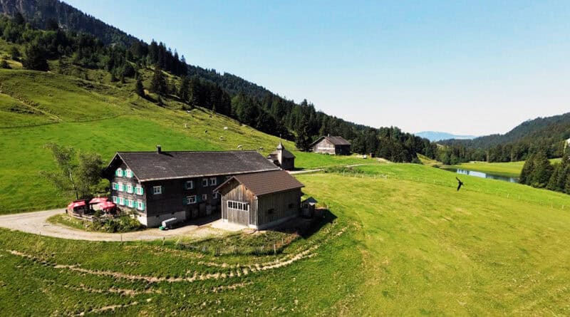 Alpe Höfle im grünen Lecknertal mit Alpengasthof, Bergwiesen, Wald und See.
