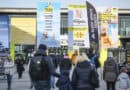 Besucherinnen und Besucher vor dem Eingang der CMT auf dem Messegelände Stuttgart mit großformatiger Tourismus- und Campingwerbung.
