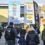 Besucherinnen und Besucher vor dem Eingang der CMT auf dem Messegelände Stuttgart mit großformatiger Tourismus- und Campingwerbung.